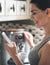 Woman checking her cell while making espresso on a Saeco Superautomatic Espresso Maker